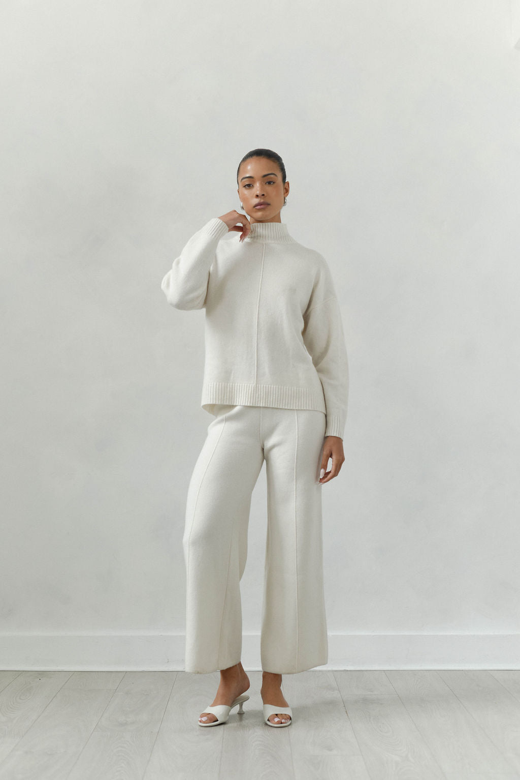 Person wearing a white outfit against a plain background